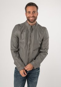 Grijze leren jas met een staande kraag, ritssluiting aan de voorkant en twee zijzakken. Bevat subtiele stikseldetails en een gladde textuur.