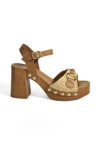 Braune Leder-Absatzsandalen mit oberer Schicht aus geflochtenem Stroh, goldenen Nieten entlang der Kante und einem verstellbaren Knöchelriemen. Holz-Blockabsatz.