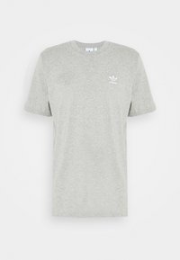 Pelēks kokvilnas T-krekliņš ar īsām piedurknēm, apaļu kakla izgriezumu un baltu Adidas logo kreisajā krūtī. Gluda tekstūra, brīva dizaina.