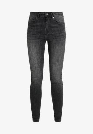 Vaqueros skinny negros de mezclilla, con una cintura alta, cinco bolsillos, costuras clásicas y un sutil desgastado para aportar textura.