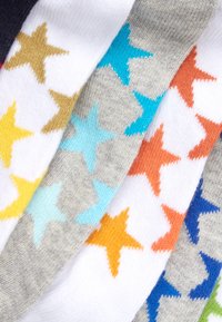 Calzini in cotone colorati con vari design che presentano stelle in arancione, blu, giallo e grigio su sfondi bianchi e chiari.