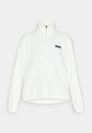 White fleece pullover with a half-zip collar, elastic cuffs, and a Patagonia logo patch. Soft texture and relaxed silhouette.