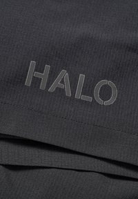 Svart texturerad tyg med ett ribbat mönster, med ordet "HALO" i fet, reflekterande bokstäver.