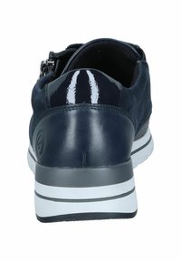 Sneaker blu navy con un tacco in vernice liscia, superiore in camoscio, chiusura con zip laterale e suola a strisce bianche.