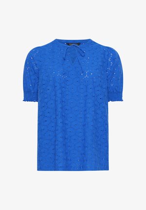 Blouse bleue à manches courtes avec motif floral en dentelle ajourée, manches bouffantes avec poignets élastiques et petit détail de lien en V au col.