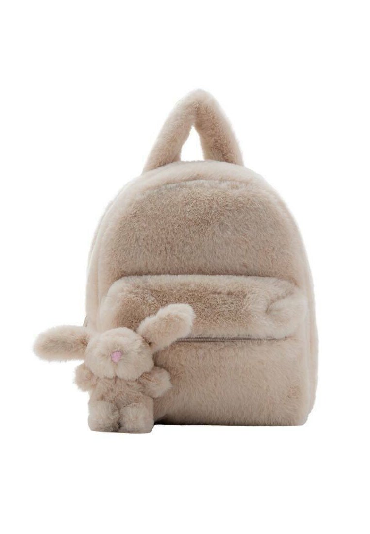 Beige bont rugzak met een ronde vorm en een kleine konijnencharme. Heeft een voorzak met rits en een zachte, gestructureerde oppervlakte.