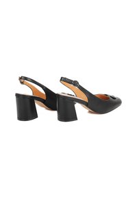 Scarpe slingback in pelle nera con punta arrotondata e tacco quadrato. Presentano una cintura regolabile e una leggera texture sulla parte superiore.