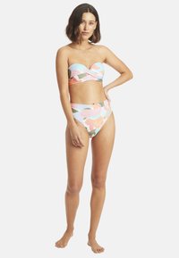 Ensemble de bikini coloré comprenant un haut sans bande avec un détail twist et un bas taille haute. Le matériau semble lisse avec un motif floral.