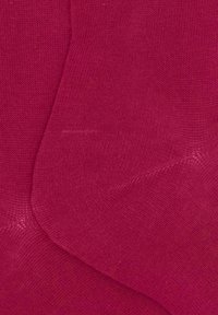 Calzini rosa lavorati a maglia con una texture liscia e un colore uniforme senza motivi, che mostrano lievi variazioni di tonalità.