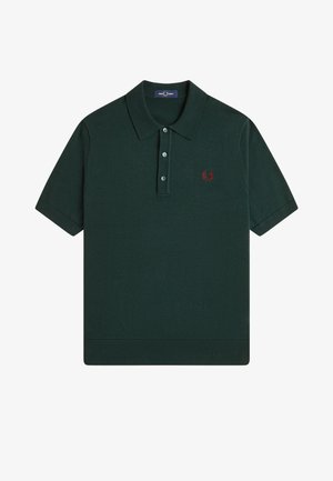 Dunkelgrünes Poloshirt mit kurzen Ärmeln, Kragen, drei Knöpfen und kleinem roten Sticklogo auf der linken Brust.