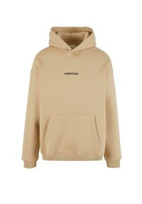 Beige sweatshirt met capuchon, gemaakt van zachte katoenen stof. Voorzien van een voorste kangoeroezak en een zwart "AnotherCotton" tekstlogo op de borst.