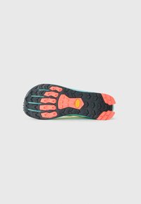 Semelle de chaussure de trail running avec un crampon en caoutchouc noir et corail et le logo Vibram au centre, conçue pour l'adhérence et la durabilité.