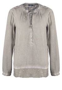 Blouse gris clair à manches longues, col rond, boutons sur le devant, détail à cordon de serrage et bordure en dentelle en bas. Texture de tissu lisse.