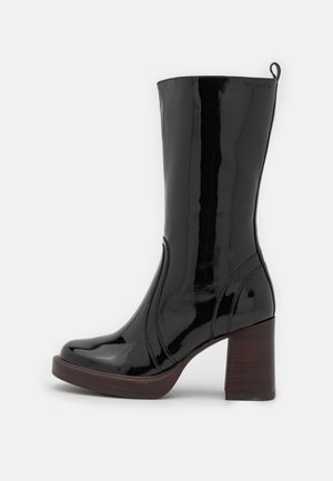 Czarny błyszczący skórzany but za kostkę, z zaokrąglonym noskiem, ozdobnym przeszyciem, pętelką z tyłu u góry oraz grubym wooden block heel.