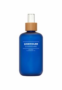 Blue glass bottle with a bamboo cap. White text label reads "KRYOLAN CLEAN&CARE NATURAL CLEANSING OIL." Smooth texture, rounded shape.