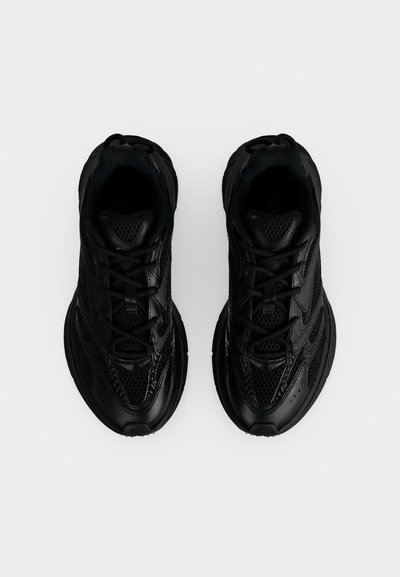 Paire de chaussures de sport noires avec détails en mesh et cuir, vues de dessus sur fond blanc.