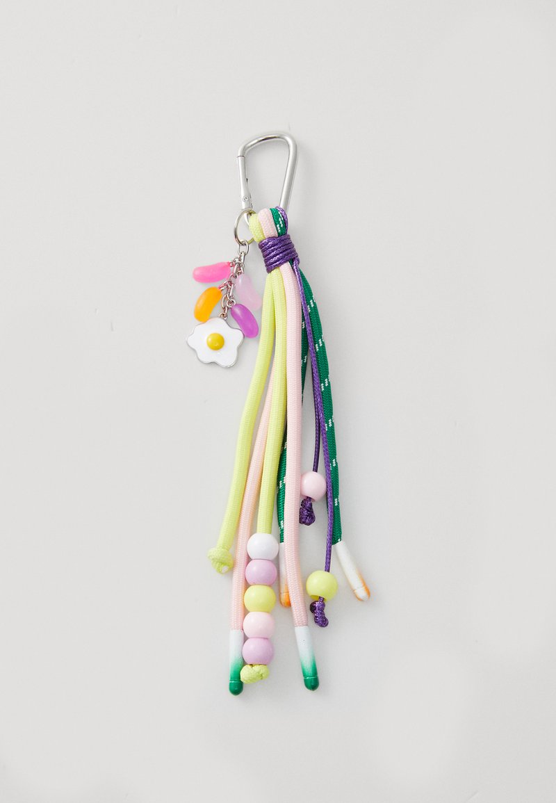 Flerfarget nøkkelring med strenger av pastellfargede snorer i rosa, grønn og lilla, med perler og en blomstercharm med gul midtpunkt.