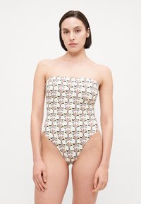 Strapless one-piece swimsuit with cream base, floral pattern in black, orange, and blue hues. High-cut leg design, smooth texture.