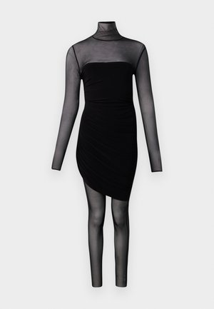 Vestido ajustado negro con mangas largas transparentes, cuello alto y tela transparente tipo leggings desde la cintura hasta los pies sobre un fondo blanco liso.