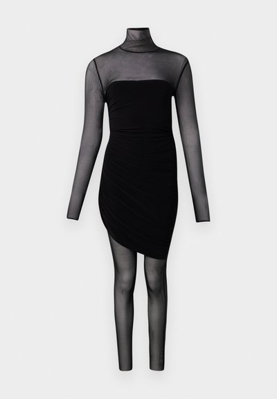 Musthave must-haves keha, millel on läbipaistvad pikad varrukad, kõrge krae ja läbipaistvast kangast leggings, mis ulatuvad vööni jalgadeni, ühevärvilise valge tausta ees.