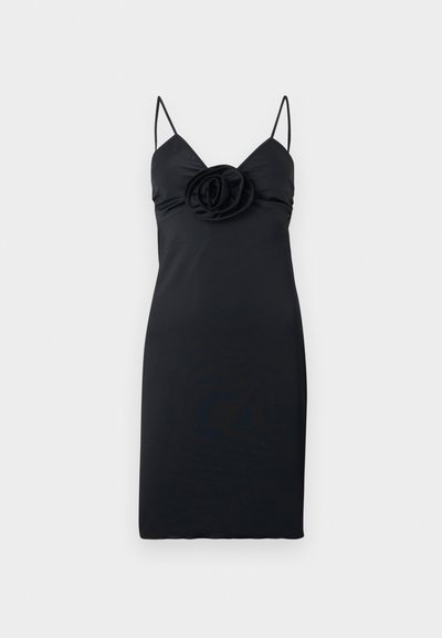 Μαύρο σατέν φόρεμα μήκους μέχρι το γόνατο με λεπτές τιράντες και μια μεγάλη υφασμάτινη ροζέτα στο κέντρο του στήθους.