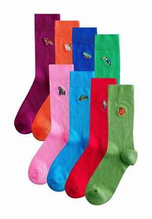 Syv farverige sokker med broderede dyrepatche inklusive en ræv, lemur, frø, tukan, gorilla, skildpadde, papegøje og orangutang.