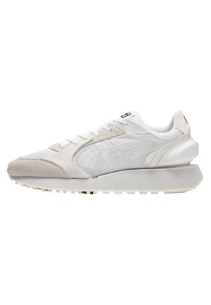 White athletic sneaker with a textured upper, suede accents, and a thick sole. Features contrasting light grey details and flat laces.