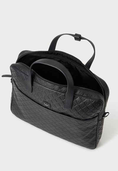 Porte-documents en cuir noir texturé avec doubles poignées, fermeture éclair ouverte dévoilant un compartiment principal spacieux, et une poche extérieure zippée.