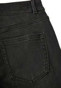 Zwarte denim jeans met een achterzak en subtiele stiksels. De stof is glad met een lichte glans en een label aan de tailleband.