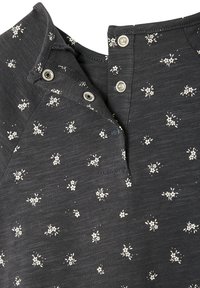 Dark gray top featuring a buttoned collar, floral print in white, and a soft, textured fabric. Includes silver snap and button details.