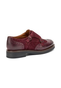 Zapato de hombre de cuero burdeos y ante con detalles de brogue, cierre de doble hebilla, acentos texturizados y suela de goma negra.