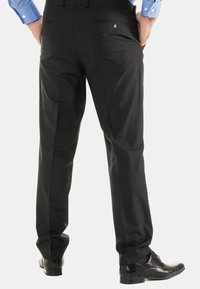 Zwarte dress pants met een gladde textuur, zij- en achterzakken, en een getailleerde pasvorm, gecombineerd met zwarte schoenen.