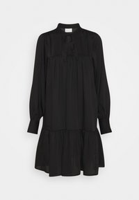 Vestido negro con mangas largas, cuello alto y un lazo en el cuello. Presenta un corpiño plisado y una falda amplia y acampanada con un dobladillo con volantes.