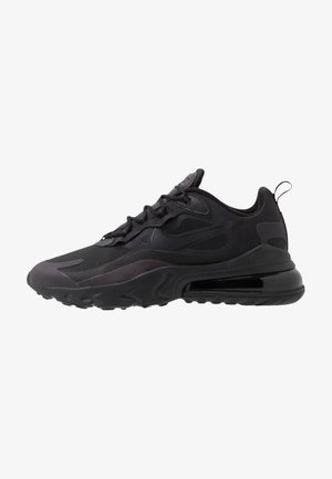 Czarny sportowy sneaker z podeszwą amortyzowaną powietrzem, teksturowanymi nakładkami, sznurowanym designem i pętelką z tyłu, pokazany w profilu bocznym.