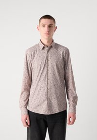 Camicia button-up rosa chiaro con piccoli motivi blu scuro e blu chiaro, maniche lunghe e colletto classico. Presenta un orlo curvato.