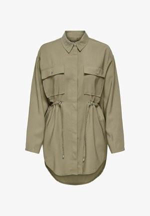 Long-sleeve khaki shirt with a button-down collar, two chest pockets, adjustable drawstring waist, and a curved, extended hem.