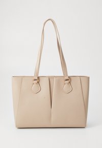 Beige tote bag laget av teksturert kunstlær, med doble håndtak og detaljer i gull hardware. Designet inkluderer et delt frontdetalj.