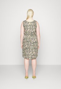 Vestido com estampa floral, de alças, com cintura ajustada e saia até ao joelho. Fundo escuro com flores cor-de-rosa e amarelas; textura de tecido suave.