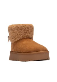 Stivale ankle in suede beige con un morbido polsino peloso. Presenta una punta arrotondata e una suola piatta in gomma con battistrada per la presa.
