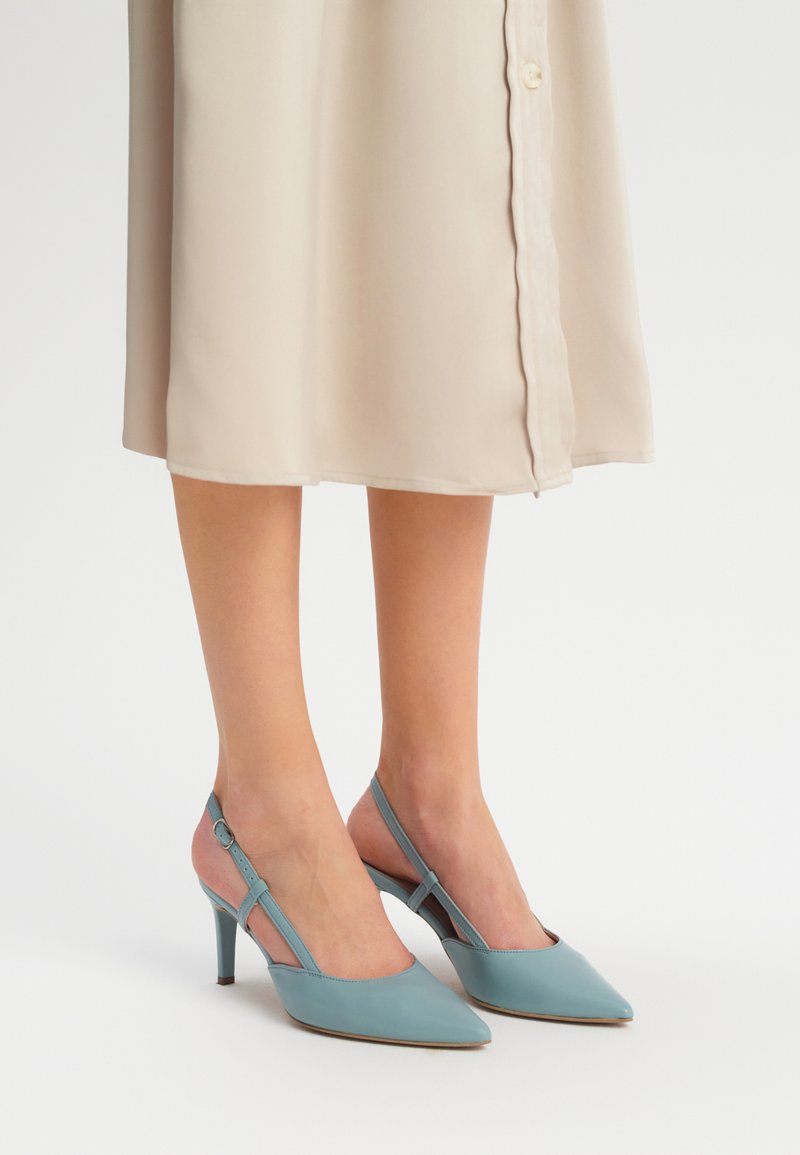 Pantofi cu toc Slingback din piele moale de culoare albastru deschis, cu vârful ascuțit, având curea pentru gleznă și toc stiletto de 5 cm.