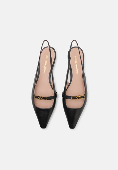 Sorte læder slingback hæle med spids tå, guld hardware accent og en beige indersål med logo. Glat tekstur og minimalistisk design.