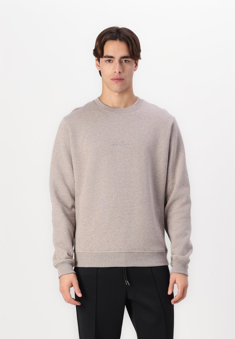 Hellgrauer Pullover aus weichem Stoff, mit Rundhalsausschnitt, langen Ärmeln und gerippten Bündchen. Minimalistisches Design mit Emblemen auf der Brust.