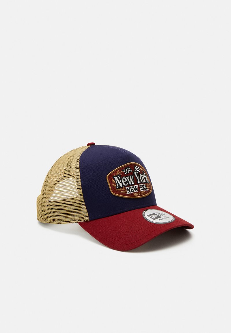 Lkw-Fahrer-Cap mit navyfarbigem Frontteil, rohem Schirm und beigem Netzrücken. Mit einem gestickten "New York"-Patch mit Schachbrettakzenten.