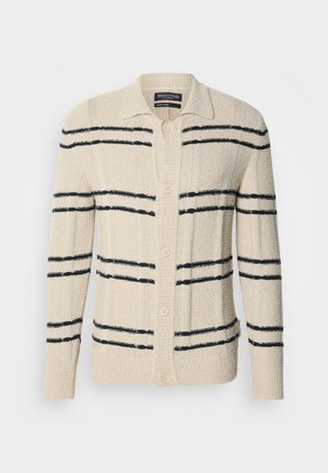 Beżowy kardigan wykonany z teksturowanego materiału, z granatowymi poziomymi paskami, kołnierzykiem i zapięciem na guziki.