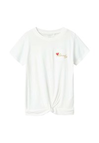 T-shirt blanc à manches courtes avec un ourlet noué. Présente un petit cœur rouge et le texte doré "lovely" sur la zone gauche de la poitrine. Tissu doux.