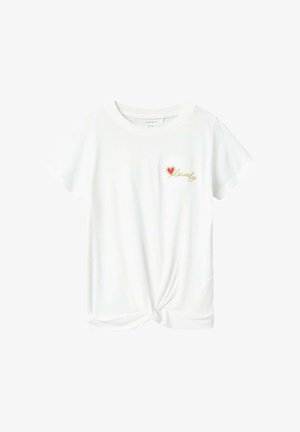 T-shirt blanc à manches courtes avec un ourlet noué. Présente un petit cœur rouge et le texte doré "lovely" sur la zone gauche de la poitrine. Tissu doux.