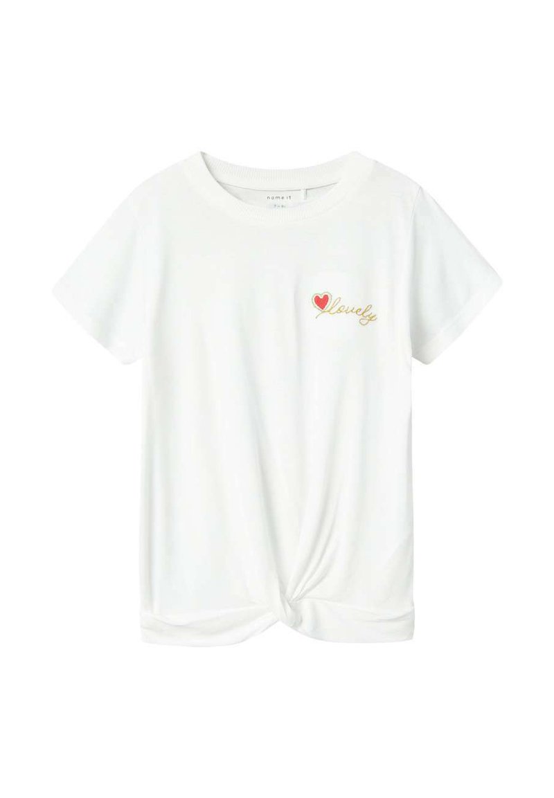 T-shirt blanc à manches courtes avec un ourlet noué. Présente un petit cœur rouge et le texte doré "lovely" sur la zone gauche de la poitrine. Tissu doux.