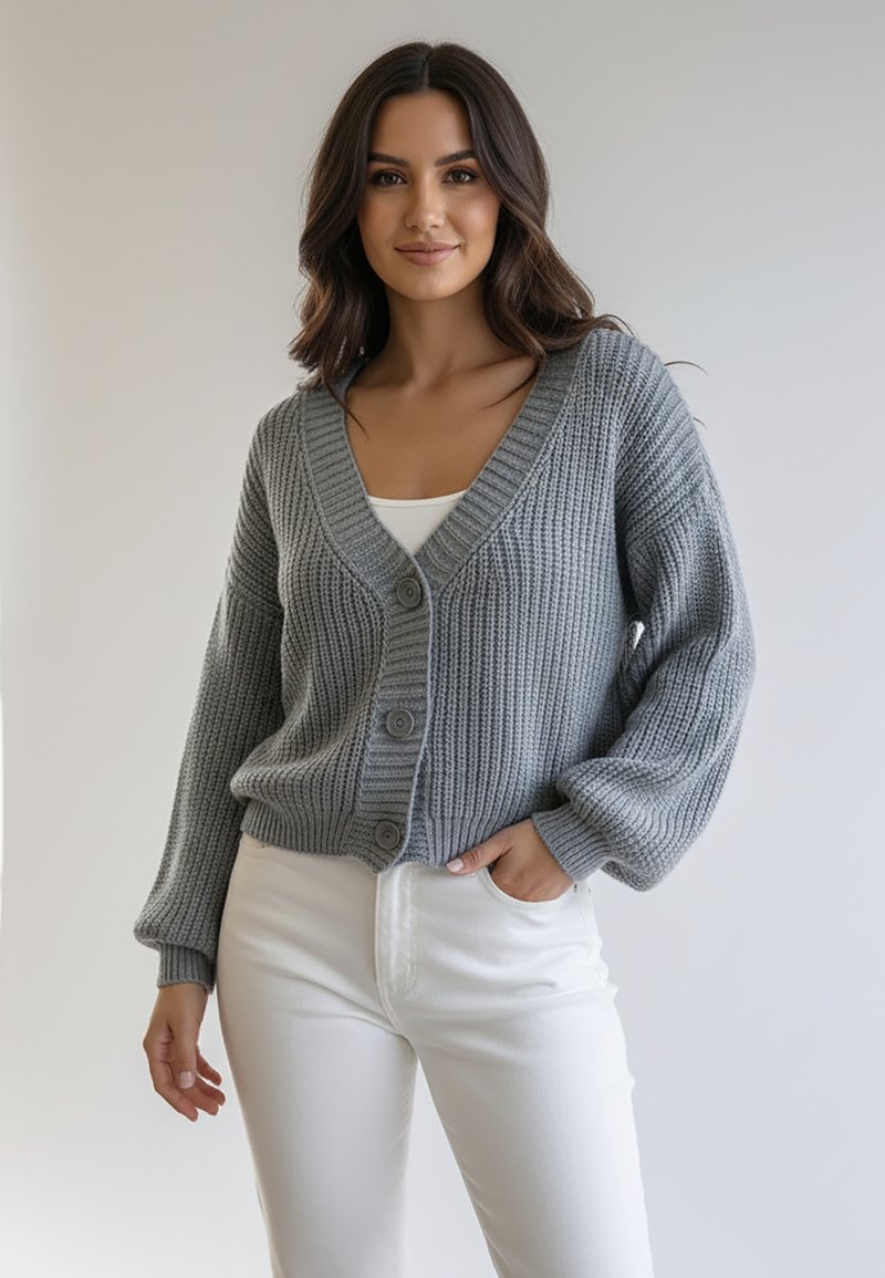 Szary dziergany kardigan z dekoltem w serek, długimi rękawami i trzema guzikami z przodu. Noszony na białej bluzce i w połączeniu z białymi spodniami.