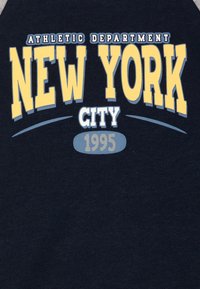 Donkerblauwe sweatshirt met "NEW YORK CITY" in grote gele letters, met daarboven "ATHLETIC DEPARTMENT" en daaronder "1995".