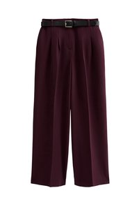 Wijde pantalon in diep bordeauxkleurige stof met een gladde textuur, voorzien van voorplooien en een zwarte riem met een rechthoekige gouden gesp.